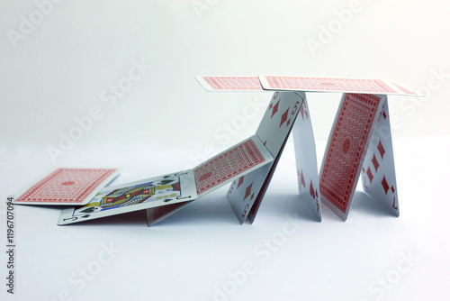 Playing cards in the form of a falling house on a white background.