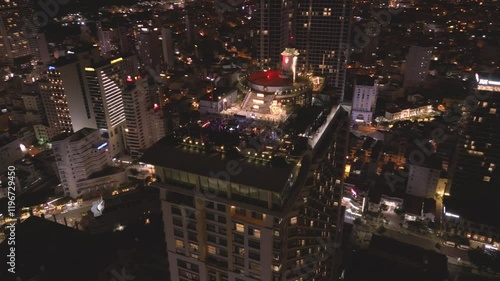 Nighttime aerial view of a vibrant cityscape showcasing illuminated skyscrapers