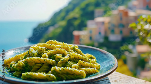 Close-up of Trofie pasta tossed in vibrant green pesto sauce, background with picturesque bright blue Mediterranean Sea at Liguria, Italian cuisine, food photography