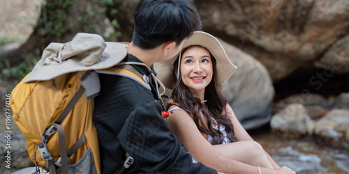 LGBT couple enjoying a playful conversation by a serene stream during their hike photo