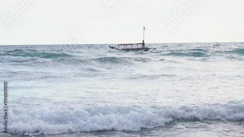 Visible from a distance, fishing boats sail in the middle of the open ocean with rather large waves photo