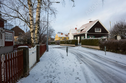 Suburban street in Scandinavia with footprints on fresh snow on calm winter day, Västerås, Sweden photo