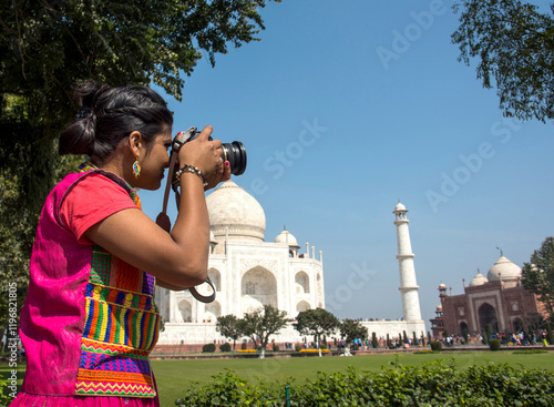 Photography Young woman tourist taking photos of Taj Mahal,