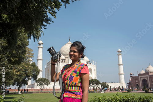 Photography Young woman tourist taking photos of Taj Mahal,
