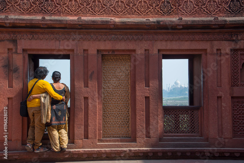 Romantic Indian couple seeing Taj Mahal from red fort, Agra, India.