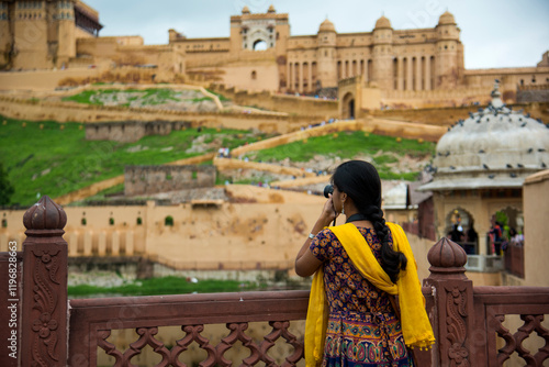 Canvas Print Woman tourist taking a photo of the Amer fort, located in Jaipur, India