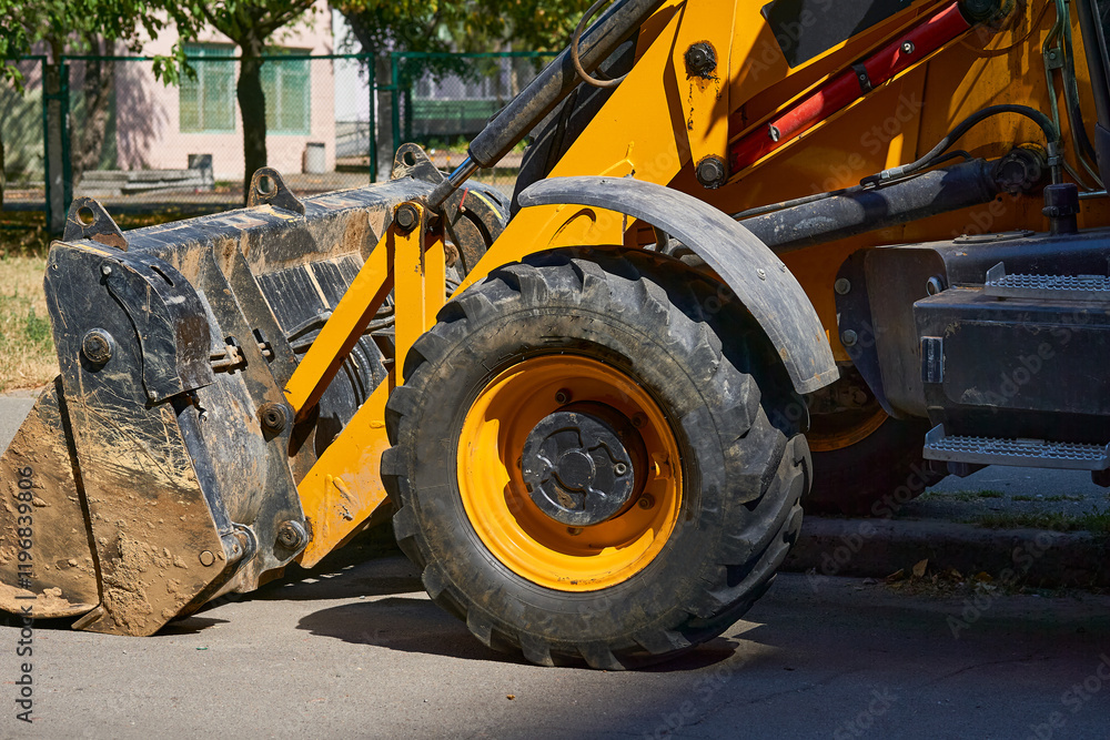 A bulldozer with a large bucket stands on an asphalt road A bulldozer with a large bucket stands on an asphalt road