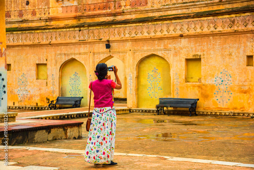 Photography Woman tourist taking a photo of the Amer fort, located in Jaipur, India