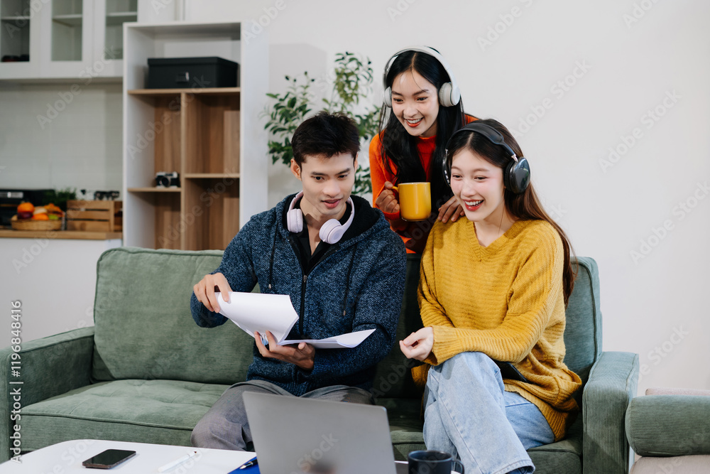 Asian college student reading a book study on laptop prepare for the exam or work on a group project at home. Asian college student reading a book study on laptop prepare for the exam or work on a group project at home.