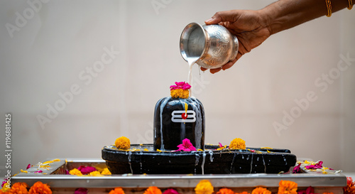 ritual  by pouring milk over a shivling decorated with flowers photo