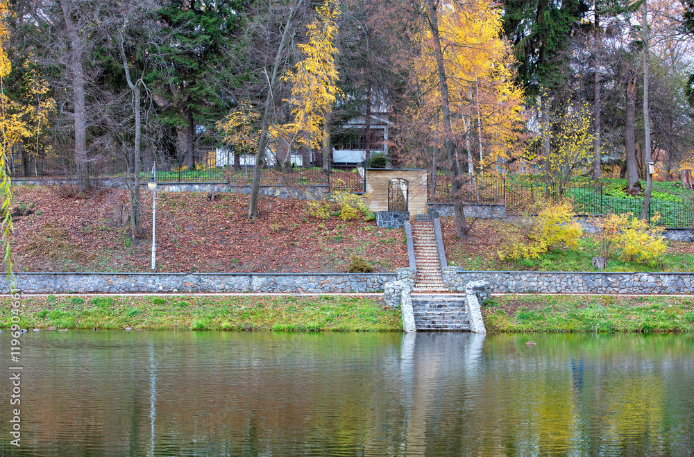 Autumn reflections by the serene lake surrounded by colorful foliage and stone steps