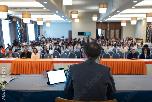 Картината върху платно A speaker, viewed from behind, addresses a large audience in a conference hall