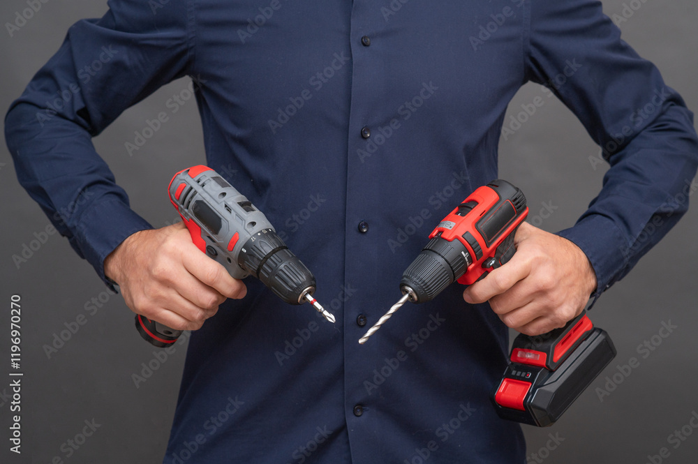 Two cordless screwdrivers in men's hands Two cordless screwdrivers in men's hands