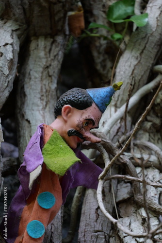 Kasper Theater Handpuppe im Wald umgeben von Efeu und Wurzeln