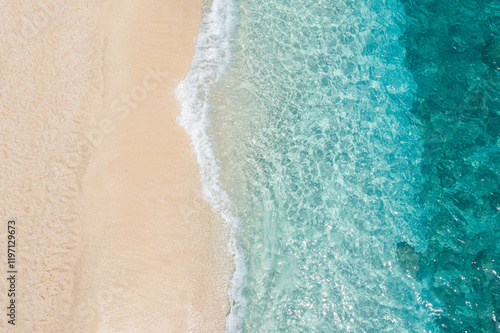 Fototapeta Naklejka Na Ścianę i Meble -  A bird's eye view of rolling waves on the beach, clear blue  sea