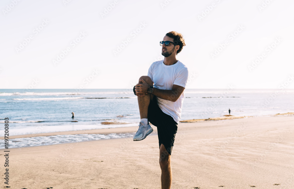 Sporty man doing warm up exercises on beach Sporty man doing warm up exercises on beach