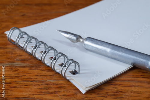 A fountain pen with a pen and a notebook on a wooden table