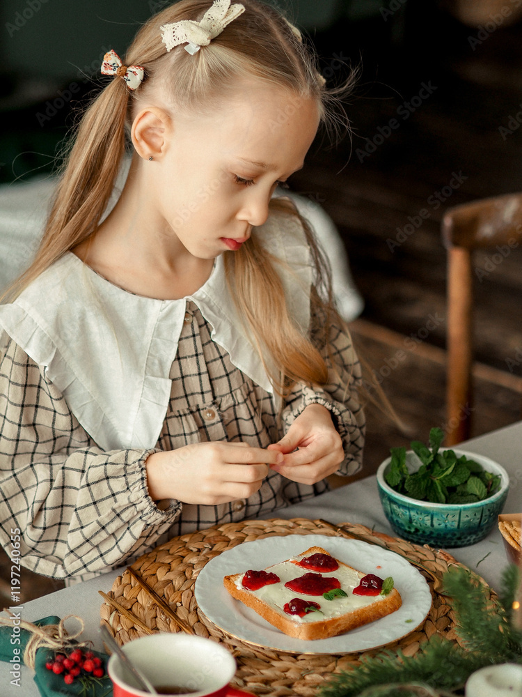 The girl makes a sandwich with jam, decorates with mint leaves. Happy baby makes breakfast The girl makes a sandwich with jam, decorates with mint leaves. Happy baby makes breakfast