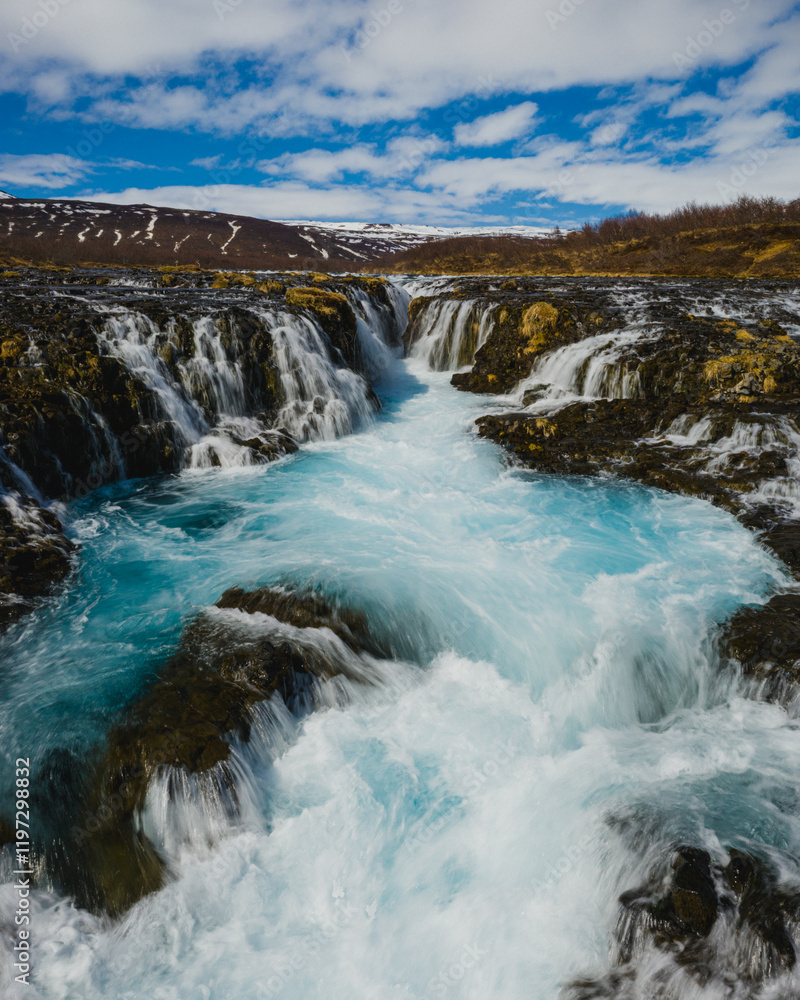 Bruarafoss waterfall with stunning turquoise waters under a bright sky in south Iceland Bruarafoss waterfall with stunning turquoise waters under a bright sky in south Iceland