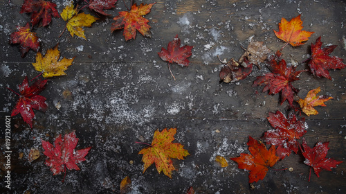 Frozen maple leaves scattered across a wooden tabletop, dusted with a delicate layer of early snow. photo