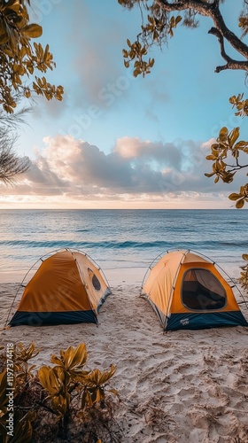 Camping by the ocean under a clear sky with two tents on the sandy beach