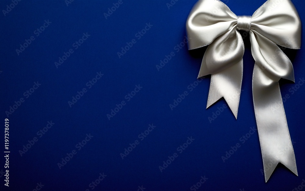 Elegant Silver Bow on Deep Blue Background Festive Gift Wrapping Decoration Elegant Silver Bow on Deep Blue Background Festive Gift Wrapping Decoration