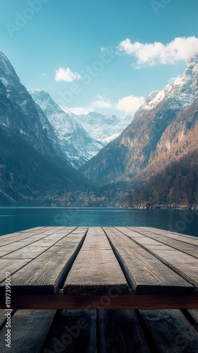 Scenic view from a wooden deck overlooking a tranquil lake surrounded by maje...