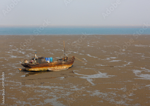 North Korean fishermen boat at low tide, South Pyongan Province, Nampo, North Korea photo