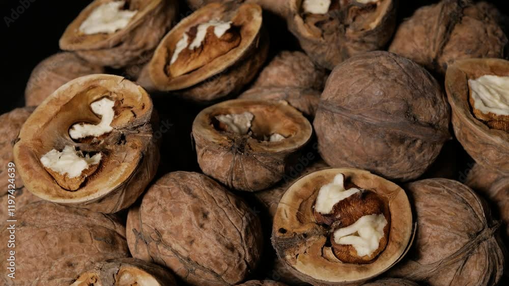 Whole and peeled walnuts rotate around an axis on a plate. Close-up. Whole and peeled walnuts rotate around an axis on a plate. Close-up.