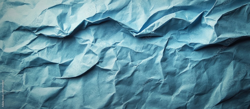 Fototapeta premium Textured blue crumpled paper background with copy space for design purposes