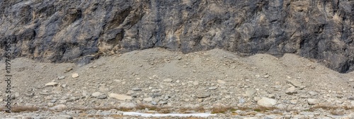 Rocky cliff face with loose debris and gravelly terrain in natural setting photo