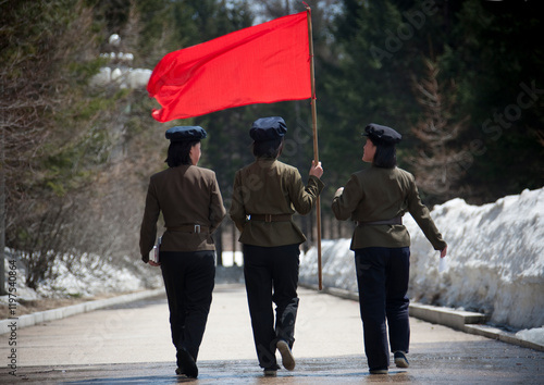 North Korean students with a red flag walking on the steps of the nation's heroes in mount Paektu, Ryanggang Province, Samjiyon, North Korea