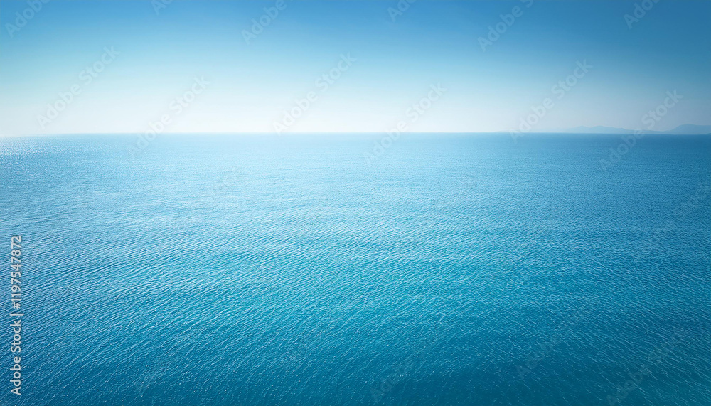 Obraz premium A serene and tranquil seascape of a calm ocean meeting a clear blue sky. The water is a crystal-clear turquoise color, and the surface is gently rippled by a soft breeze.
