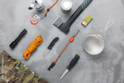 Bushcraft or survival equipment on concrete background. Flat lay composition.