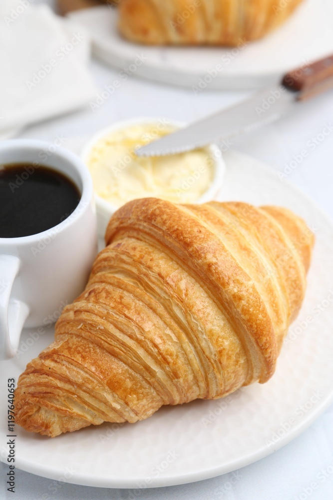 Tasty fresh croissant served with butter and cup of coffee on white table, closeup Tasty fresh croissant served with butter and cup of coffee on white table, closeup