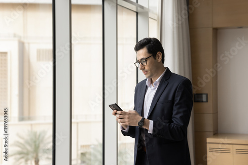 Wallpaper Mural Young Arabian businessman holding smartphone, checking messages, scheduling business meetings, browsing wireless internet, lead correspondence to company client by e-mailing, manage workflow using app Torontodigital.ca