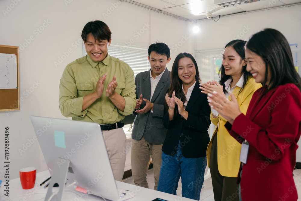 Obraz premium Diverse group of smiling business professionals is applauding a successful online presentation or video conference in a bright modern office, showing teamwork and achievement