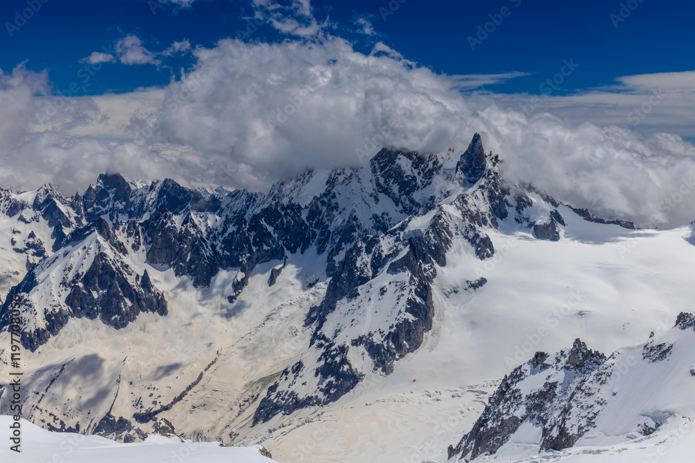Obraz premium View of snow mountain glaciers at the high altitude in the Alps. Stunning mountain landscape with high snow peaks and summits of Mont Blanc mountain range from Aiguille du Midi summit