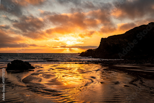 Sunset at low tide om Porth Dafarch Beach Anglesey photo