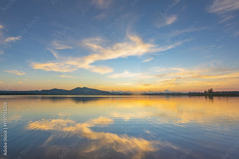 Obraz premium Landscape of mountains and lake at sunset and clouds reflected in the water.