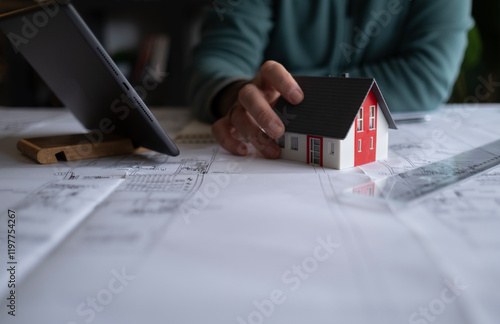 Architect man holding pencil working with laptop and blueprints for architectural plan, engineer sketching a construction project concept.
