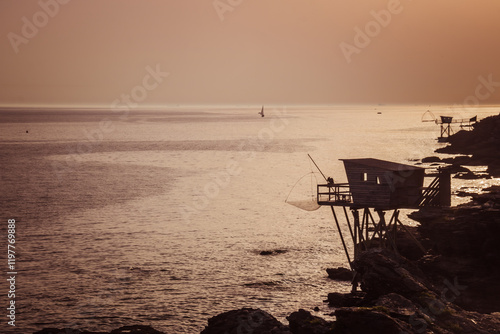 Paysage de la Loire atlantique: coucher de soleil sur les pêcheries traditionnelles de la côte atlantique face à l'océan à Pornic en France photo