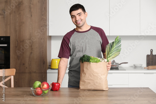 Young man with grocery bag ...