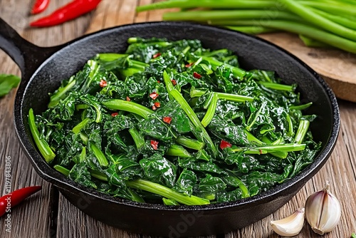 Cast iron skillet filled with freshly sauteed kale and chili peppers