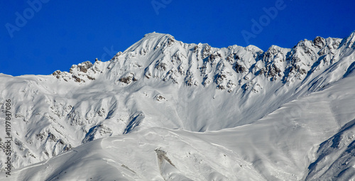 Majestic Snow-Covered Mountain Peaks Against Clear Sky in Georgia photo