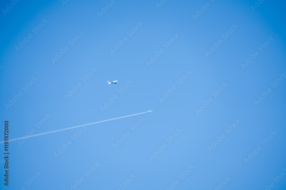 Airbus A380 and a twin engined jet liner aircraft in deep blue sky, contrails vapour trails Airbus A380 and a twin engined jet liner aircraft in deep blue sky, contrails vapour trails
