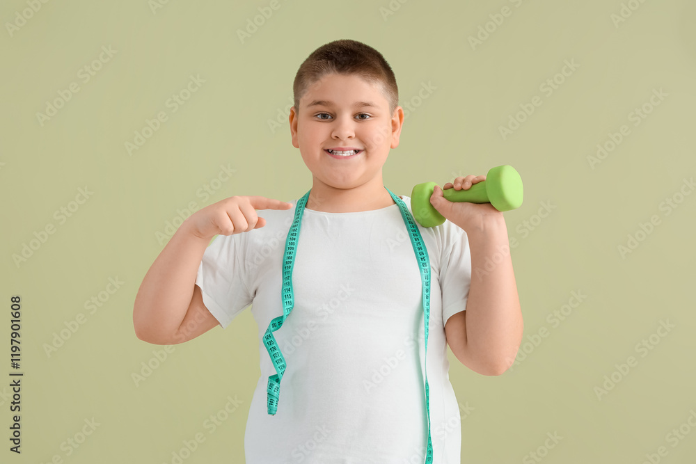 Overweight boy pointing at dumbbell on green background. Diet concept Overweight boy pointing at dumbbell on green background. Diet concept