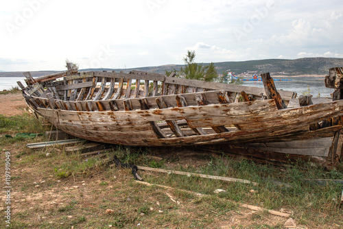 The frame of an old ship with old planks on the seashore