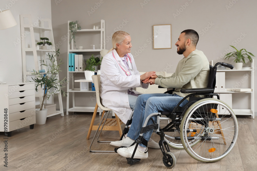 Female doctor with young man in wheelchair holding hands at hospital Female doctor with young man in wheelchair holding hands at hospital