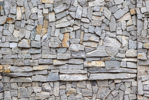 Interlocking gray stone wall with varied textures and patterns photo